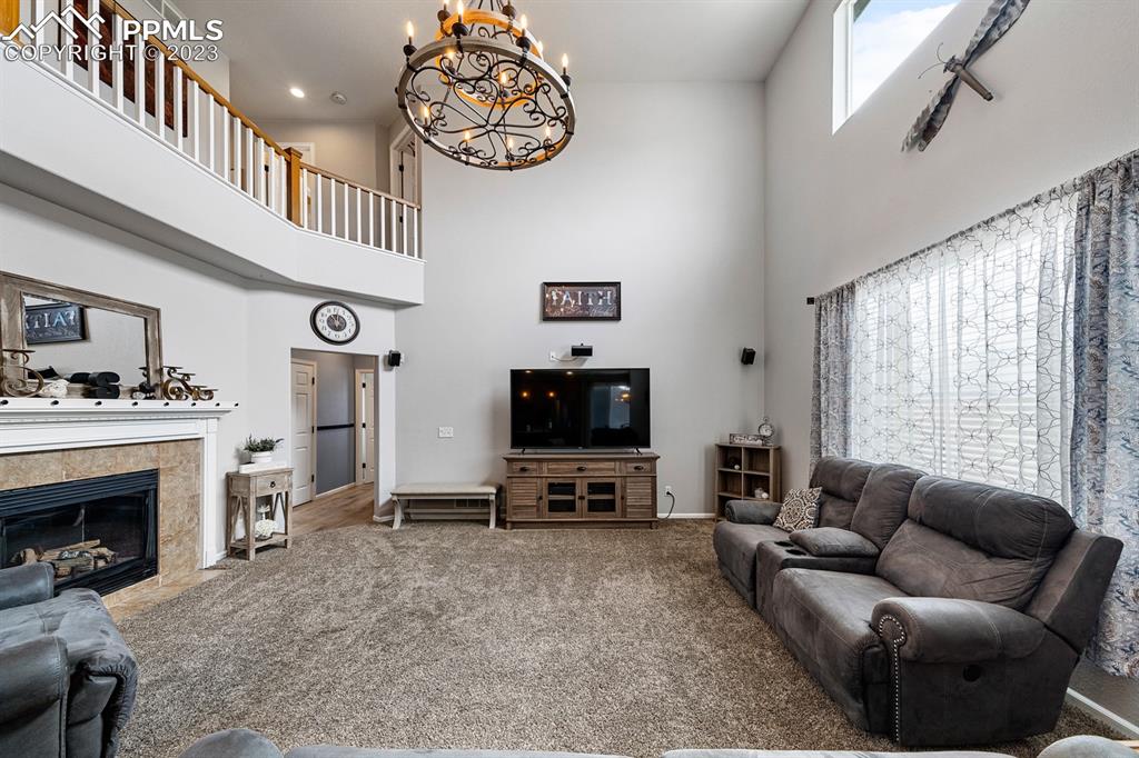 1465 Bowstring Road Monument, CO 80132 - Photo 20 of 49 a living room with furniture a fireplace and a flat screen tv
