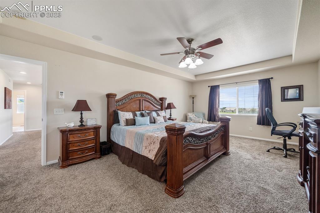 1465 Bowstring Road Monument, CO 80132 - Photo 25 of 49 a bedroom with a bed and a chandelier