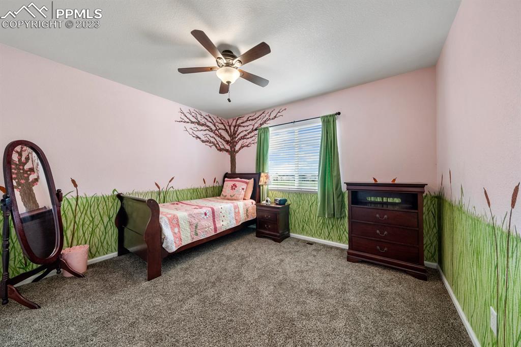 1465 Bowstring Road Monument, CO 80132 - Photo 30 of 49 a bed room with a bed and a chandelier