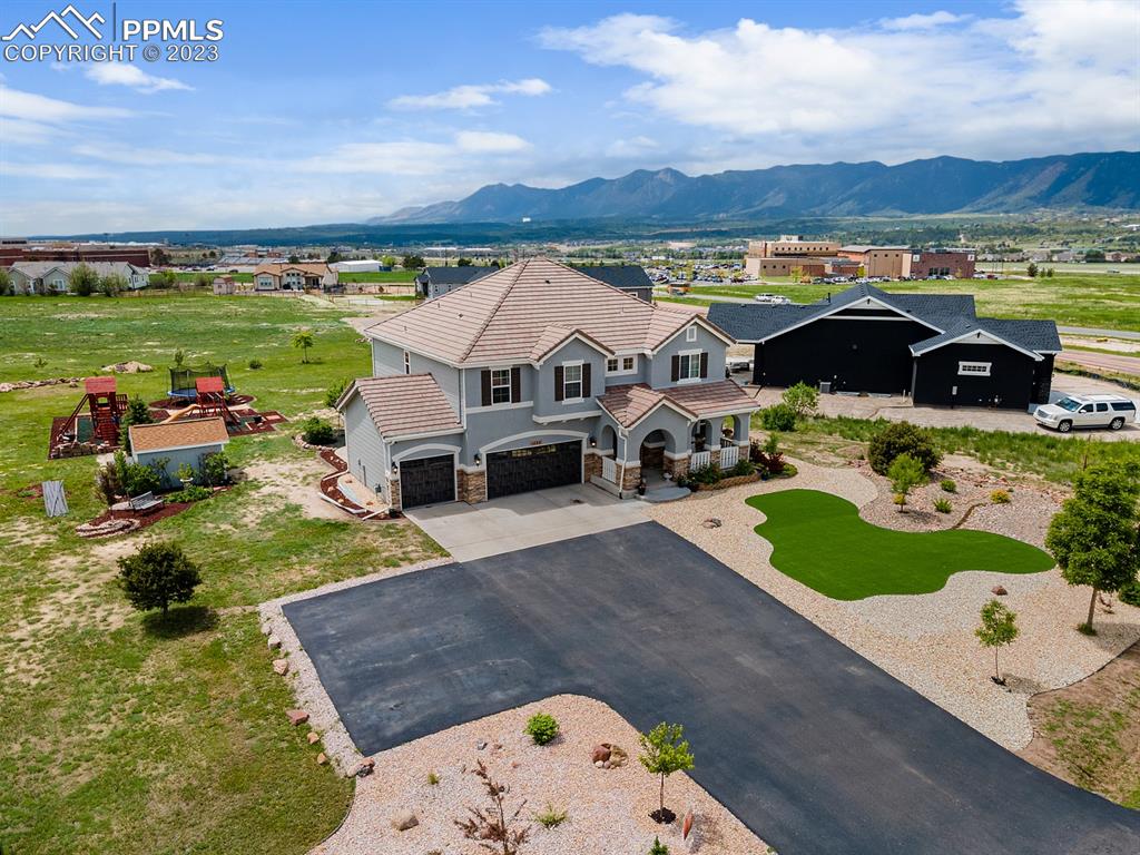 1465 Bowstring Road Monument, CO 80132 - Photo 3 of 49 an aerial view of a house with outdoor space and a garden