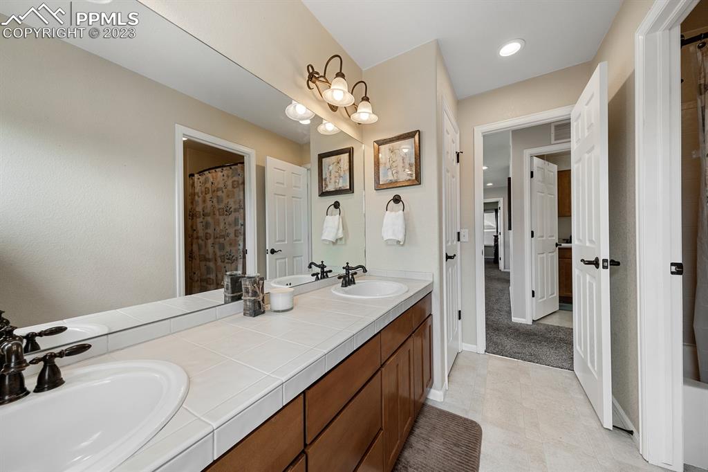 1465 Bowstring Road Monument, CO 80132 - Photo 31 of 49 a spacious bathroom with a sink double vanity and a mirror