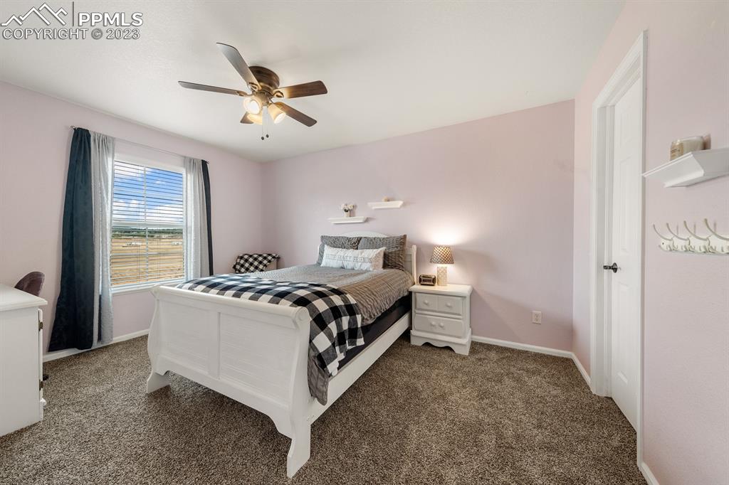 1465 Bowstring Road Monument, CO 80132 - Photo 34 of 49 a spacious bedroom with a bed and a window