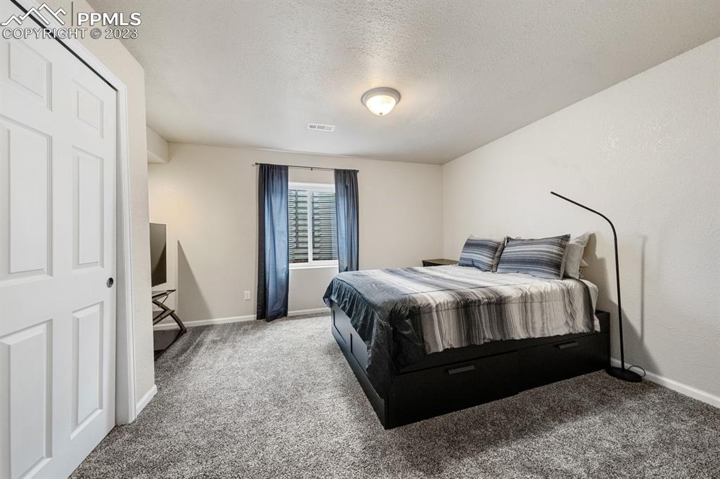 1465 Bowstring Road Monument, CO 80132 - Photo 44 of 49 a bedroom with a bed wooden floor and a window
