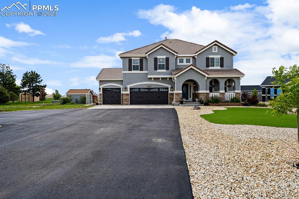 1465 Bowstring Road Monument, CO 80132 - Photo 7 of 49 a front view of a house with a yard and garage