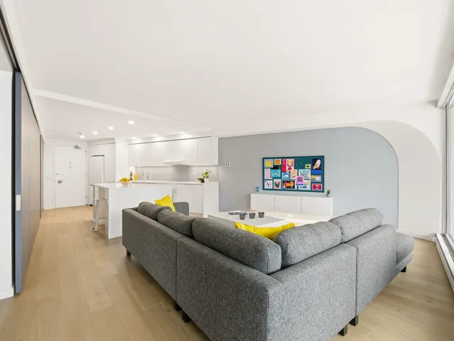 a living room with furniture and a view of kitchen