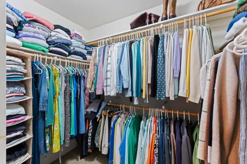 a view of walk in closet with clothes and shoes