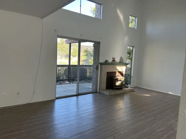 a view of a livingroom with wooden floor and a fireplace