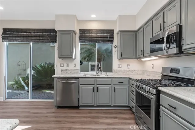 a kitchen with stainless steel appliances granite countertop a stove a sink and a microwave