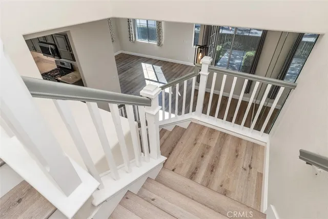 a view of staircase with wooden floor and white walls