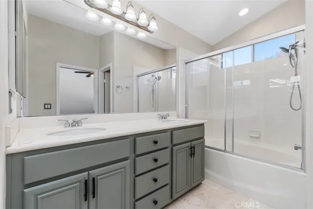 a spacious bathroom with a granite countertop sink a mirror a shower and a bathtub