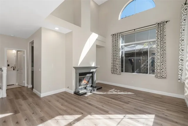 a view of a livingroom with wooden floor and a fireplace
