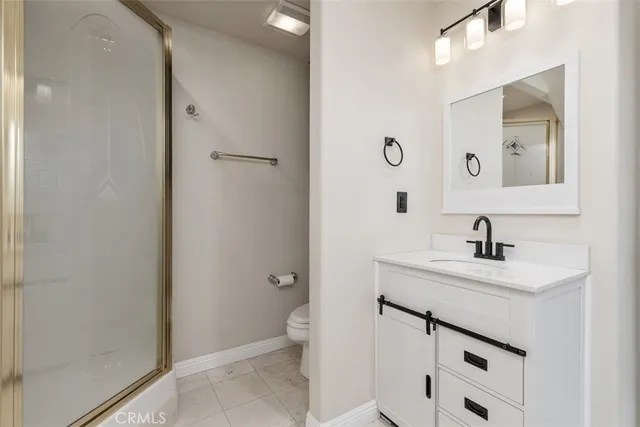 a bathroom with a sink toilet vanity and shower