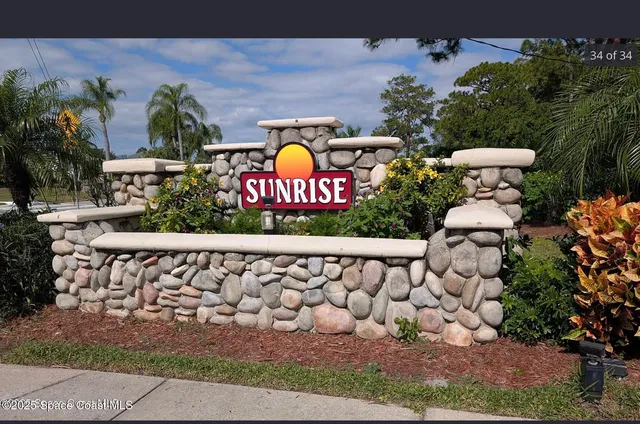 a sign that is sitting in front of flowers