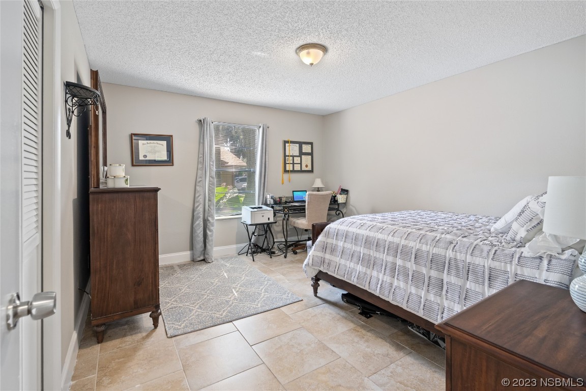 1109 Regent Street Edgewater, FL 32132 - Photo 14 of 27 a bedroom with a bed and table chair