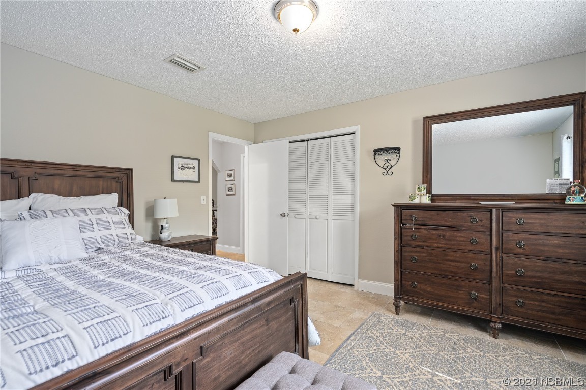 1109 Regent Street Edgewater, FL 32132 - Photo 15 of 27 a bedroom with a bed and a mirror on dresser