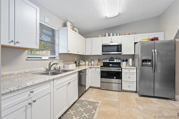 a kitchen with granite countertop a refrigerator and a sink