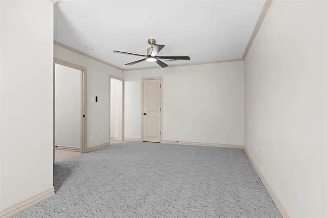an empty room with a ceiling fan and a window