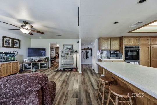 1213 Andrea Court Ridgecrest, CA 93555 - Photo 14 of 50 a large living room with stainless steel appliances granite countertop furniture a fireplace a flat screen tv and a faucet
