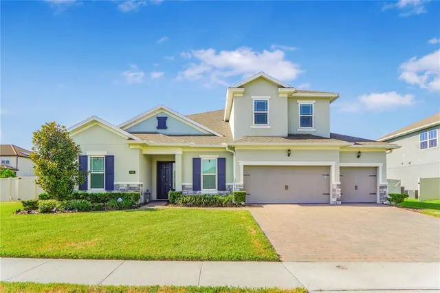 a view of a white house with a big yard and potted plants