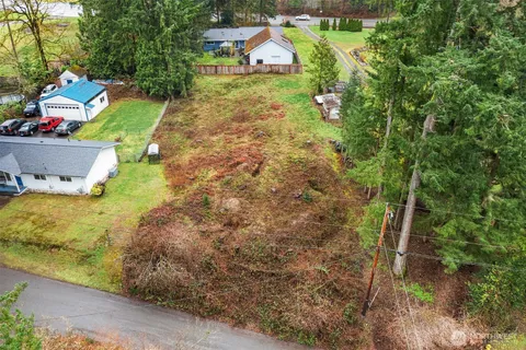 a aerial view of a house with a yard and large trees