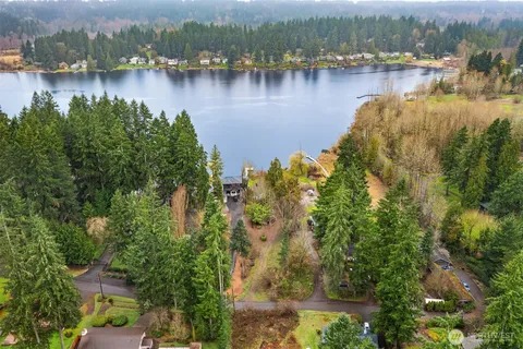 an aerial view of a residential houses with outdoor space and lake view