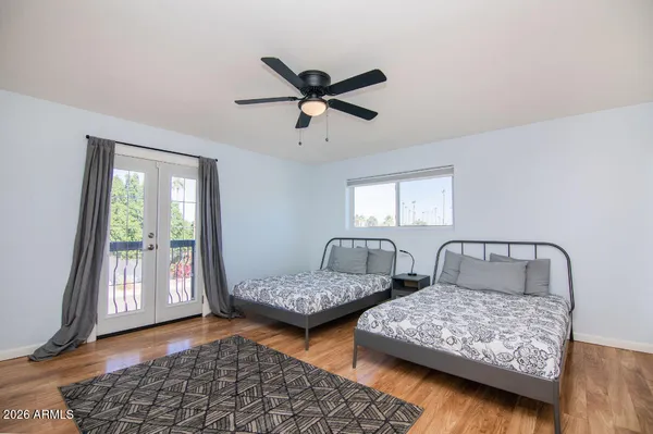 a bedroom with two beds and next to a window