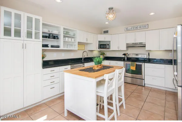 a kitchen with stainless steel appliances granite countertop a stove a sink dishwasher and a refrigerator