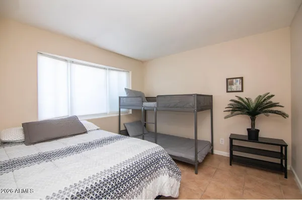 a bedroom with a bed and a potted plant