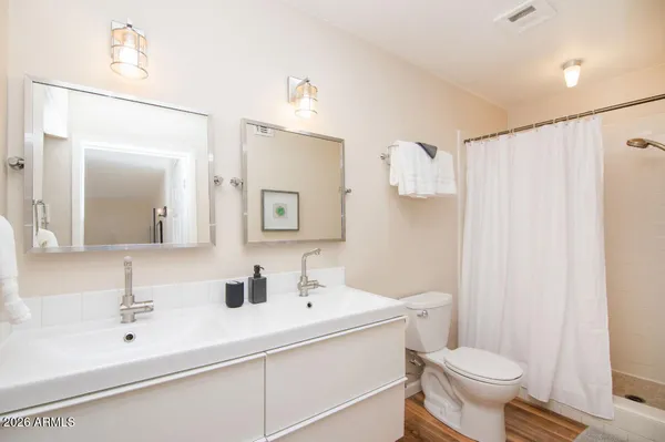 a bathroom with a sink toilet a mirror and shower