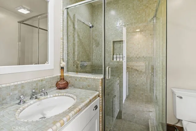 a bathroom with a sink a toilet and shower