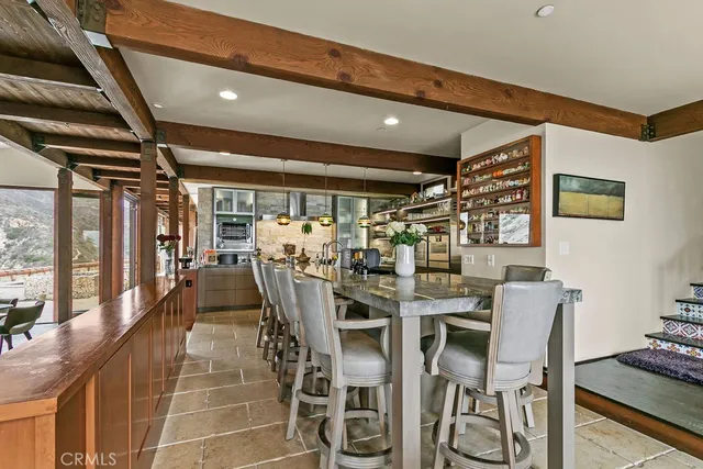 a dining room with stainless steel appliances kitchen island granite countertop a table and chairs