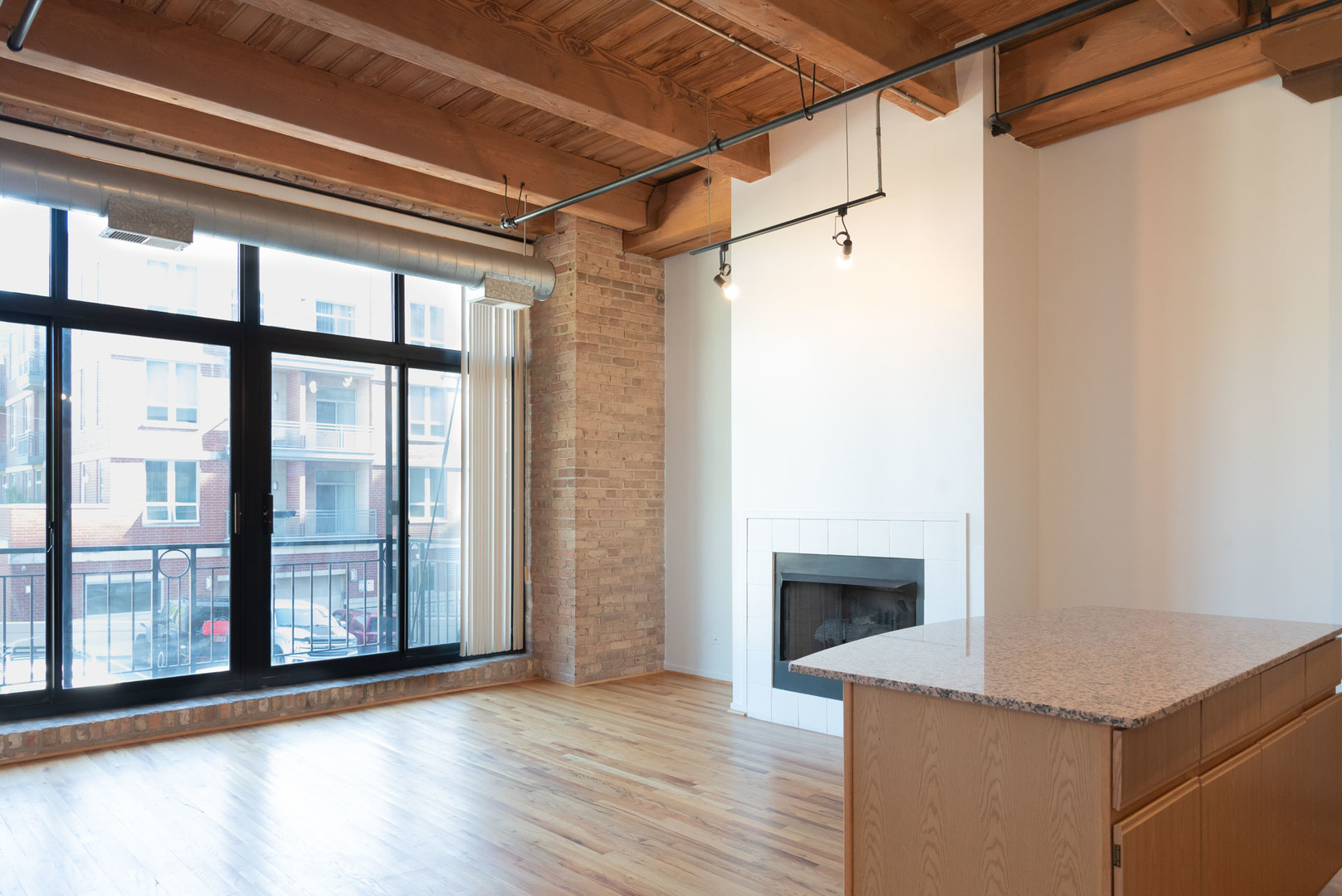 1250 West Van Buren Street, Unit 203 Chicago, IL 60607 - Photo 2 of 15 a view of a room with wooden floor and fireplace