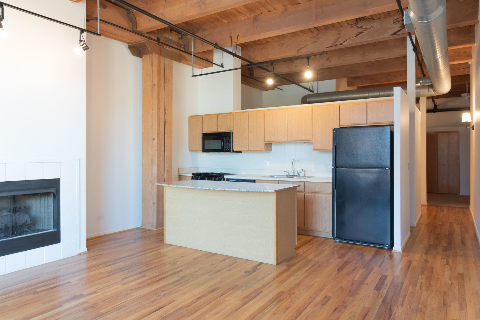 1250 West Van Buren Street, Unit 203 Chicago, IL 60607 - Photo 3 of 15 a kitchen with a refrigerator and a wooden floor