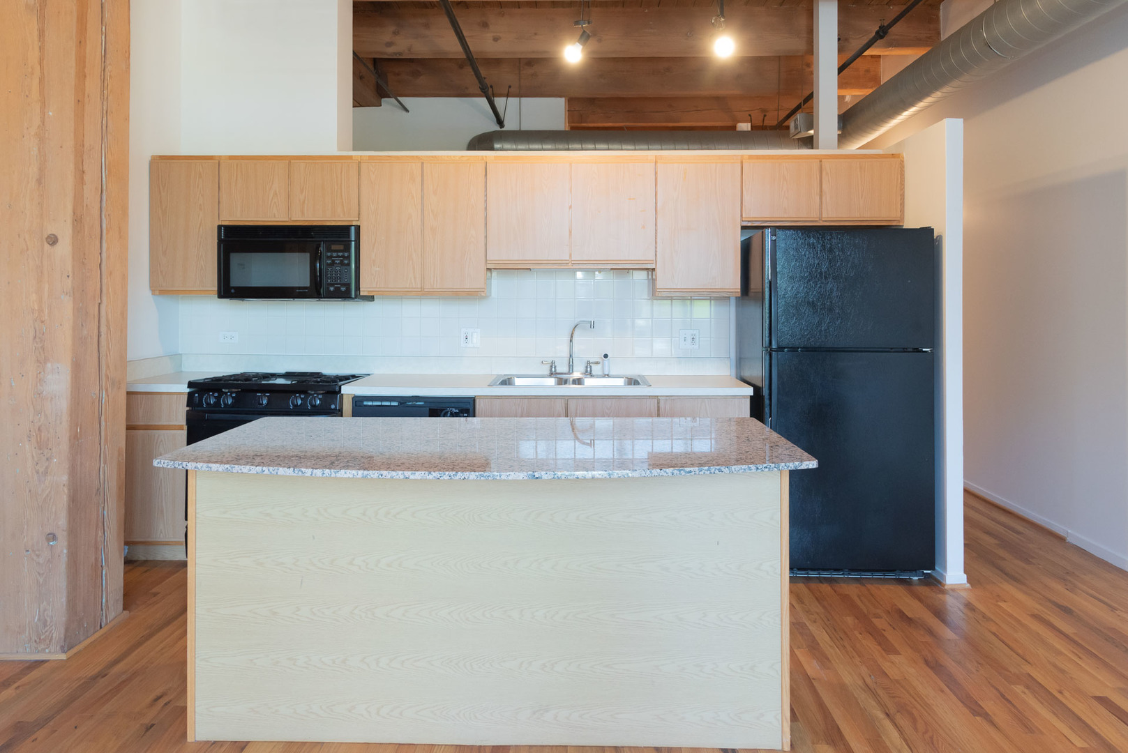 1250 West Van Buren Street, Unit 203 Chicago, IL 60607 - Photo 5 of 15 a kitchen with a sink a microwave a refrigerator and cabinets