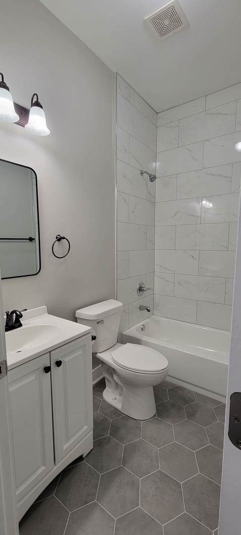 4105 West Cermak Road Chicago, IL 60623 - Photo 8 of 14 a bathroom with a toilet sink vanity tub and shower