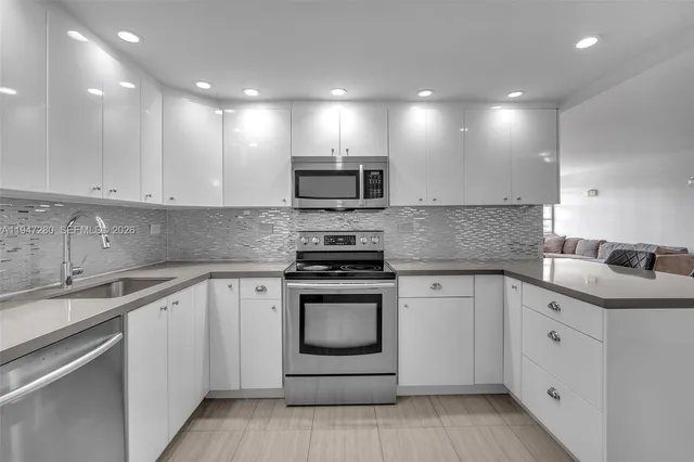 a view of kitchen with stainless steel appliances kitchen island table and chairs