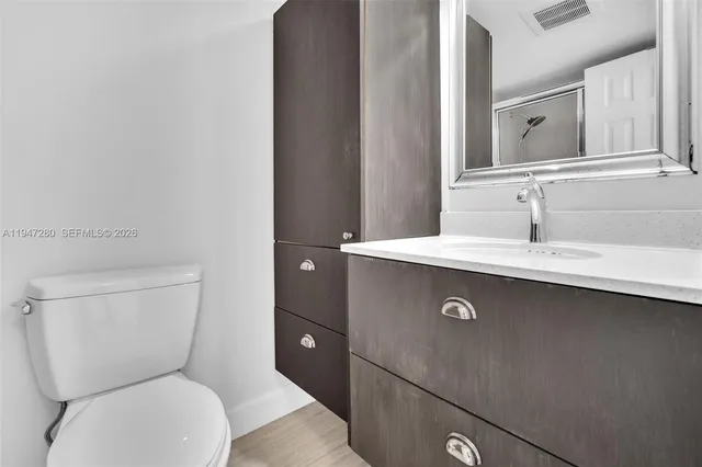 a bathroom with a toilet sink and mirror