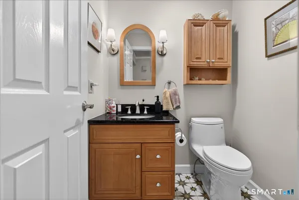 a bathroom with a granite countertop toilet sink and mirror