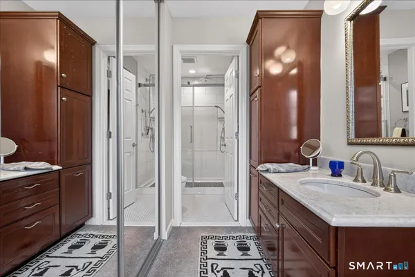 a bathroom with a granite countertop double vanity sink and mirror