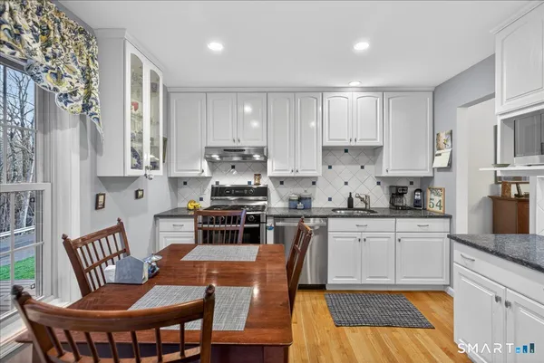 a kitchen with stainless steel appliances granite countertop a stove a sink a microwave a refrigerator and cabinets