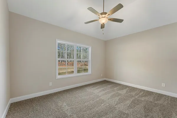 an empty room with a window and a fan
