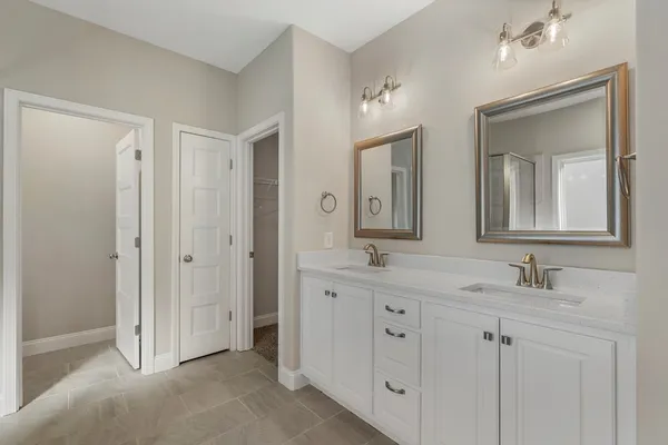 a bathroom with double vanity sinks and a mirror