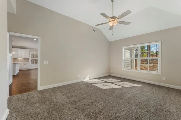 an empty room with fan and windows