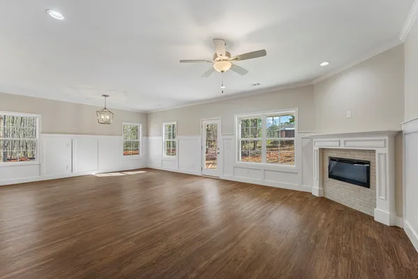 an empty room with windows and fireplace