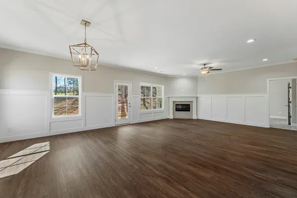 a view of empty room with wooden floor and fireplace