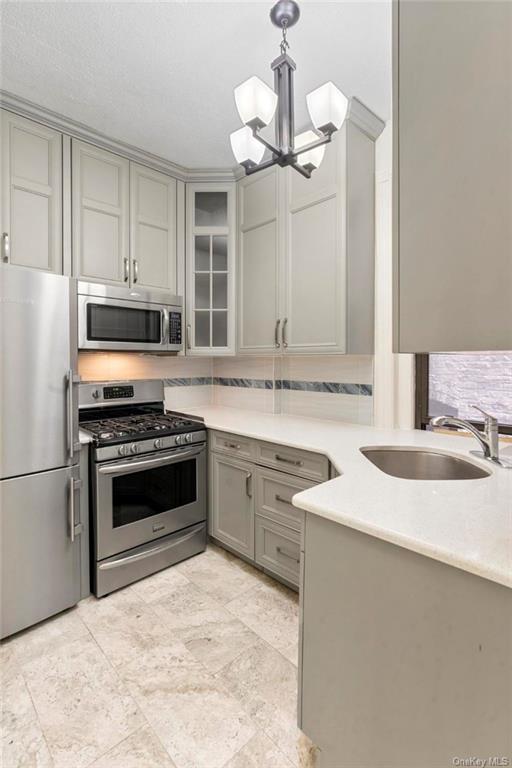 a kitchen with granite countertop a sink stainless steel appliances and cabinets