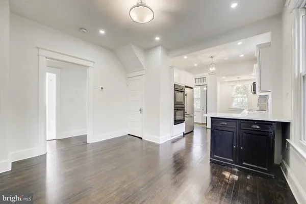 an empty room with wooden floor and window