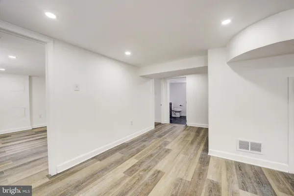 a view of an empty room with wooden floor