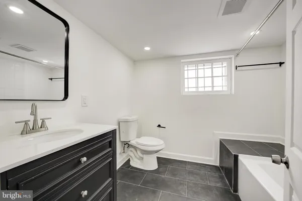 a bathroom with a sink a toilet a mirror and shower
