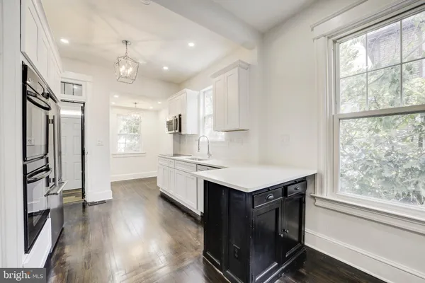 a kitchen with a sink a center island cabinets and a window